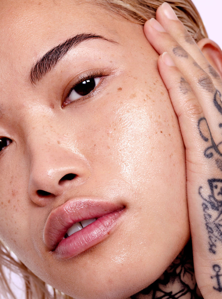 Close up of a female model using Skin Proud serum