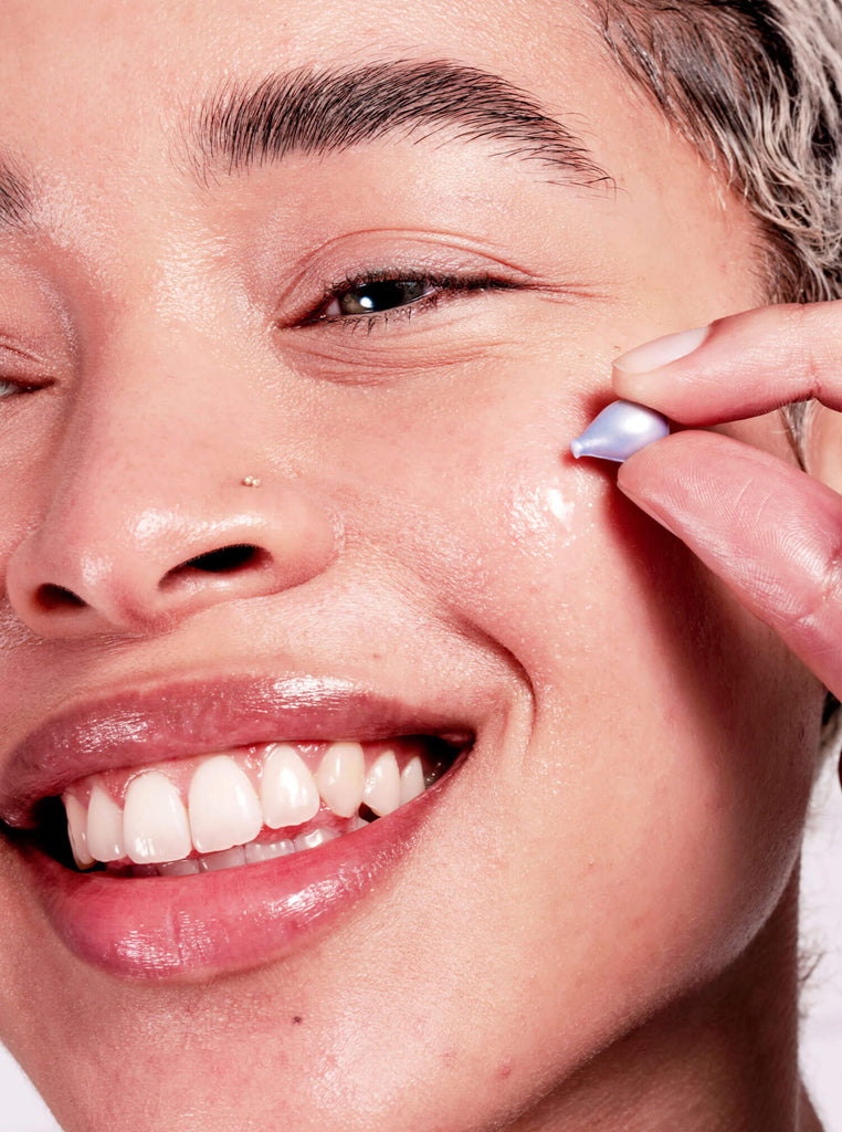 Close up of model applying Proud Pod to cheek