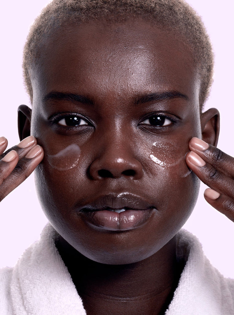 Model applying Skin Proud Recharge serum to cheeks