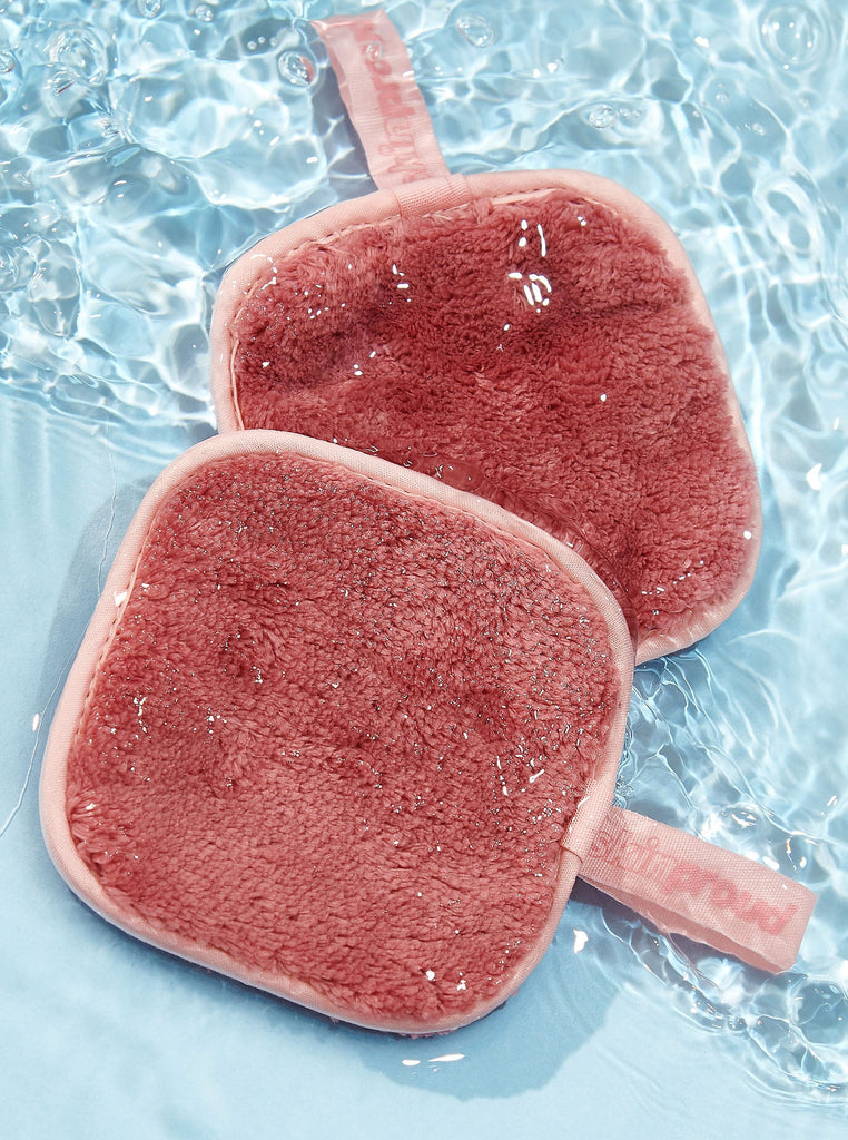 Pink makeup remover pads splashing in water