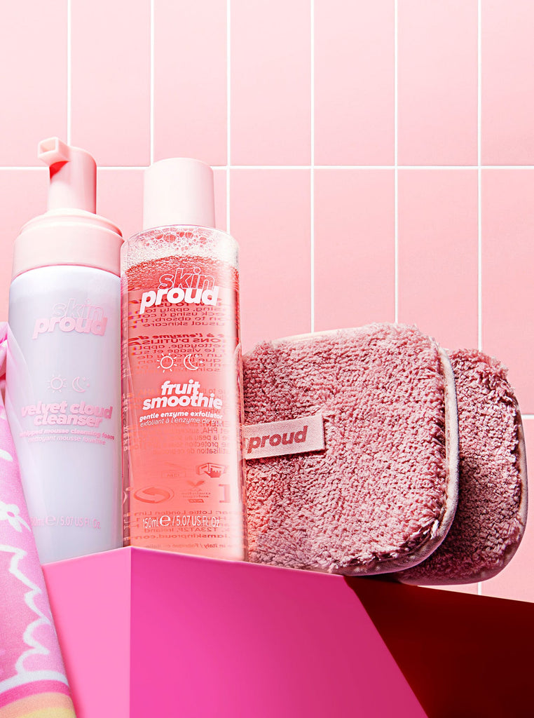 Bottles of skin care products next to two makeup remover pads