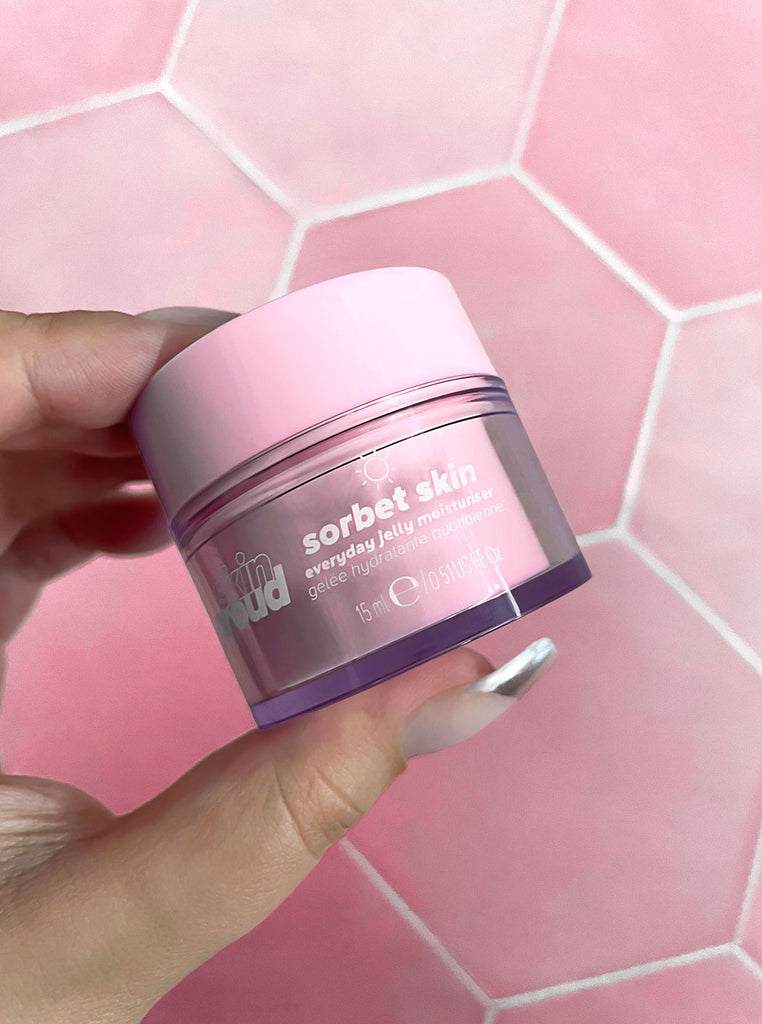 Close up of hand holding Mini Sorbet Skin container